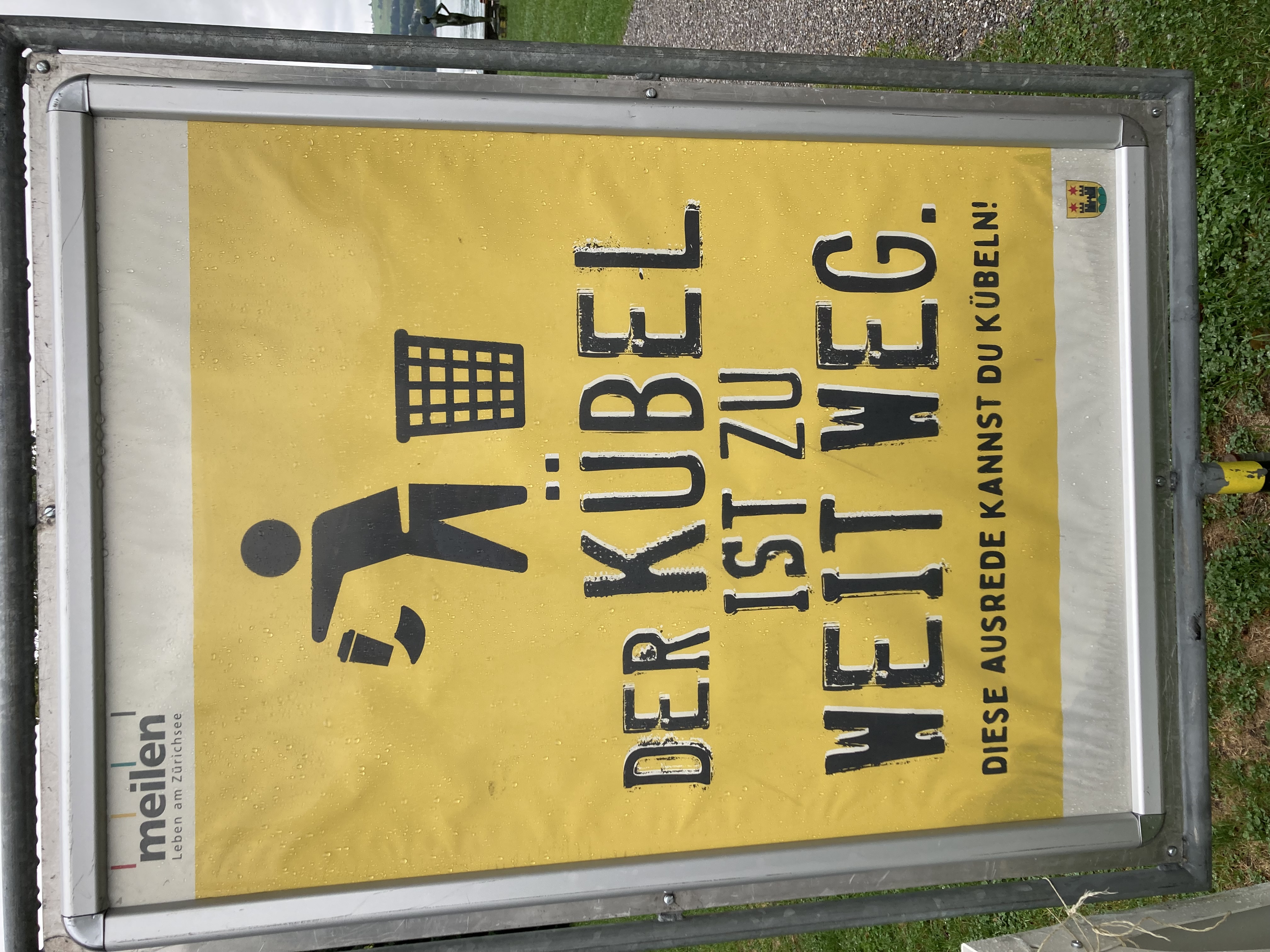 Littering-Kampagne der Gemeinde Meilen zugunsten des Abfallbehälters. Slogan auf Plakat: „DER KÜBEL IST ZU WEIT WEG, diese Ausrede kannst Du kübeln!“